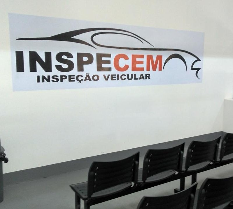 Sala de espera da Inspecem, com a logo na parede e cadeiras para os clientes